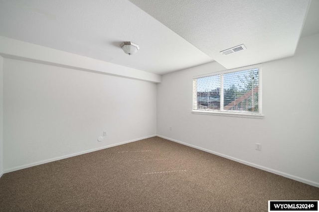 carpeted empty room featuring a textured ceiling