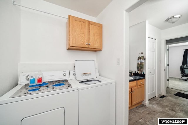 laundry room featuring cabinets, dark hardwood / wood-style flooring, and washing machine and dryer