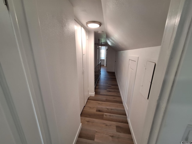 hall with dark hardwood / wood-style flooring and lofted ceiling