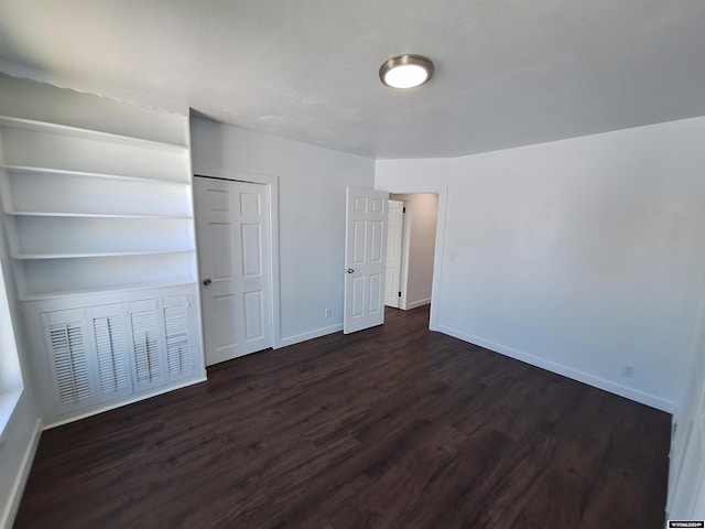 unfurnished bedroom featuring dark hardwood / wood-style flooring and a closet