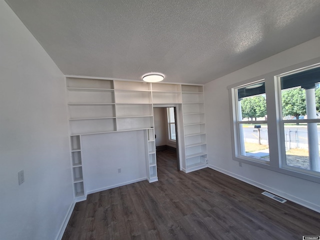 unfurnished bedroom featuring a textured ceiling and dark hardwood / wood-style floors