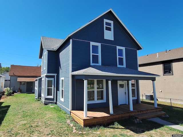 back of property featuring a porch and a yard