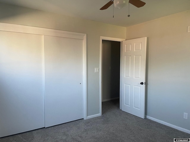 unfurnished bedroom featuring dark carpet, a closet, and ceiling fan