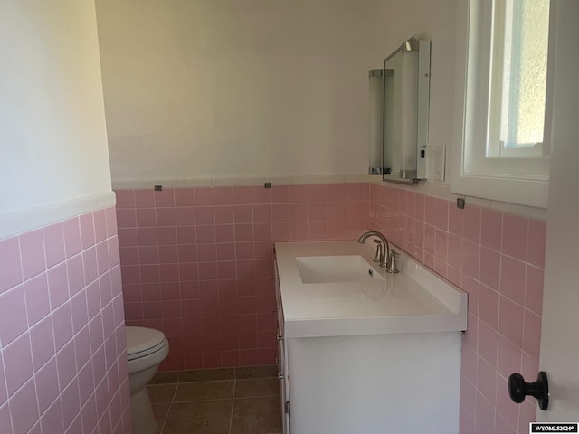 bathroom with vanity, tile walls, and toilet