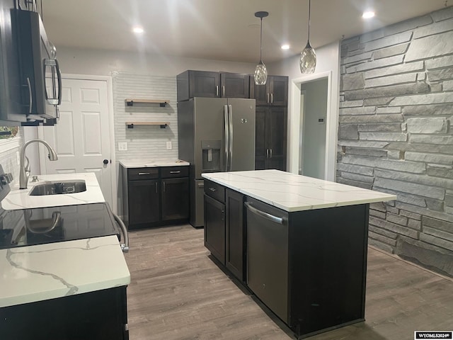 kitchen with decorative light fixtures, stainless steel appliances, hardwood / wood-style floors, and a center island