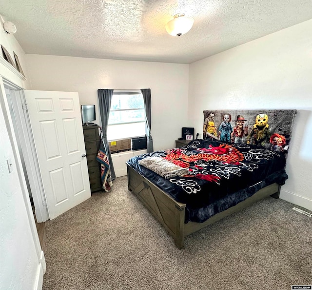 bedroom with a textured ceiling and light colored carpet