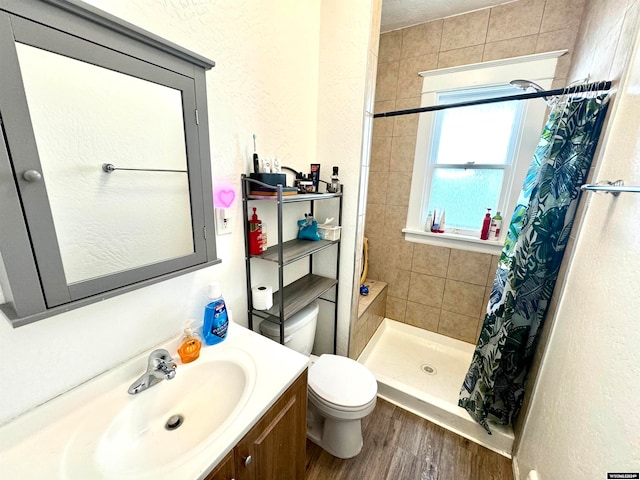 bathroom with hardwood / wood-style floors, vanity, toilet, and a shower with curtain