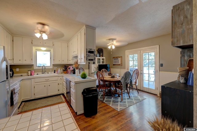 kitchen featuring white cabinetry, a textured ceiling, ceiling fan, hardwood / wood-style flooring, and sink