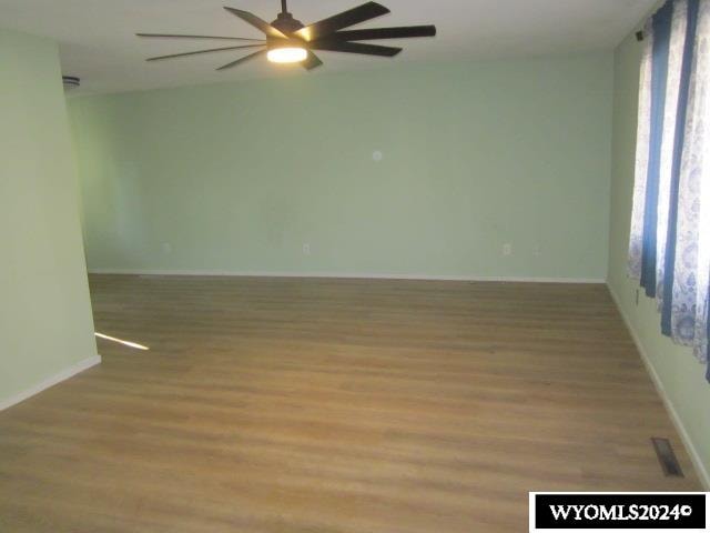 empty room with ceiling fan and hardwood / wood-style floors