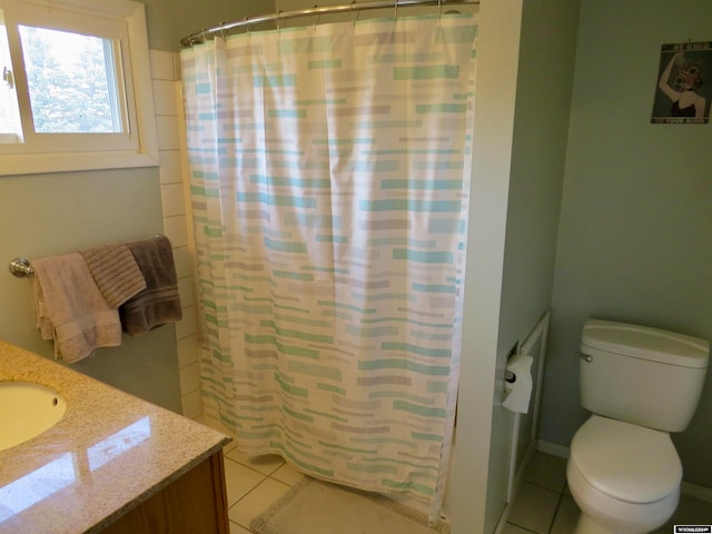 bathroom featuring walk in shower, vanity, toilet, and tile patterned floors