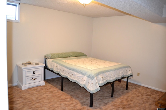 bedroom with light colored carpet and a textured ceiling