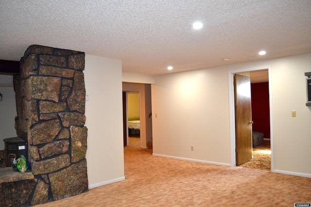 empty room featuring a textured ceiling and light colored carpet