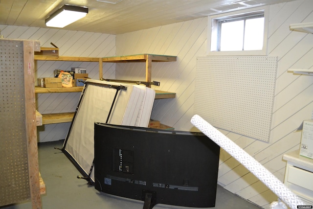 interior space featuring concrete floors and wooden walls