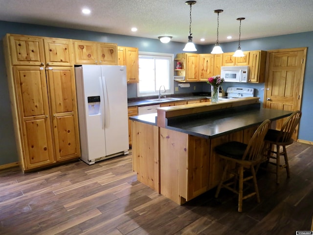 kitchen featuring pendant lighting, white appliances, a kitchen island, dark hardwood / wood-style flooring, and a textured ceiling