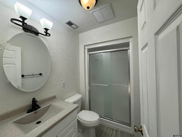 bathroom featuring vanity, walk in shower, toilet, and wood-type flooring