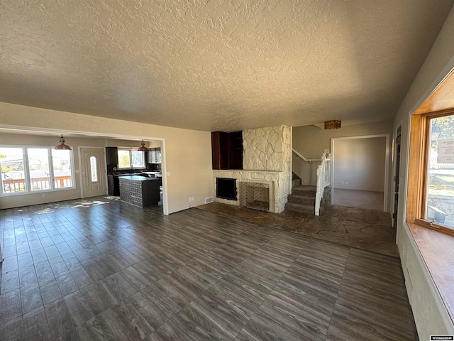 unfurnished living room with a textured ceiling and a fireplace