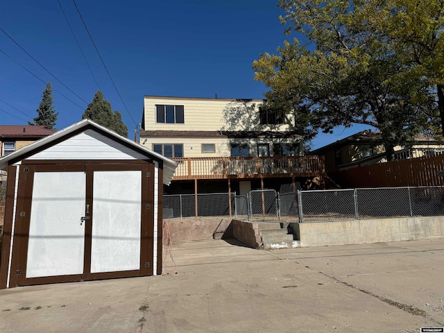 rear view of house featuring a deck and a storage unit