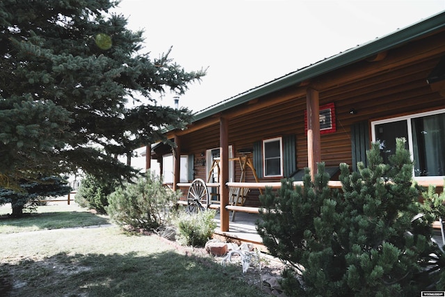 view of side of home featuring a yard and a porch