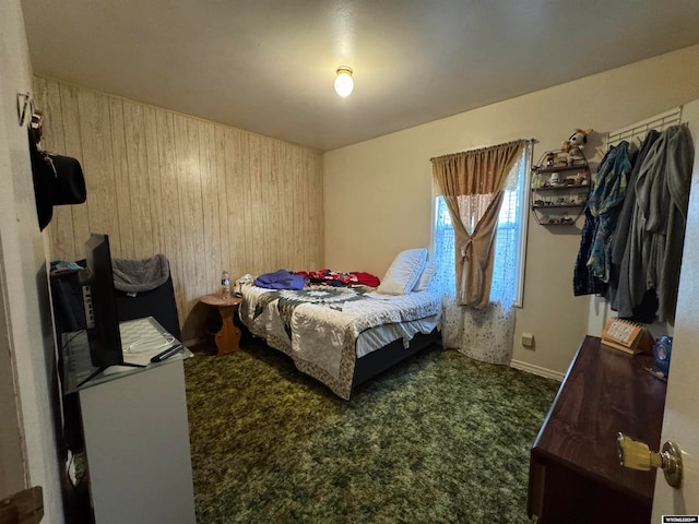 carpeted bedroom with wooden walls