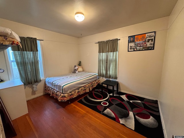 bedroom with multiple windows and hardwood / wood-style floors