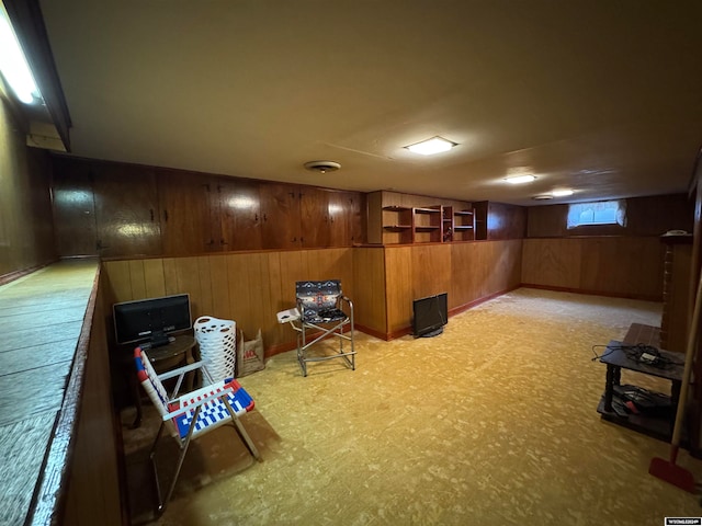 basement featuring wood walls and light carpet