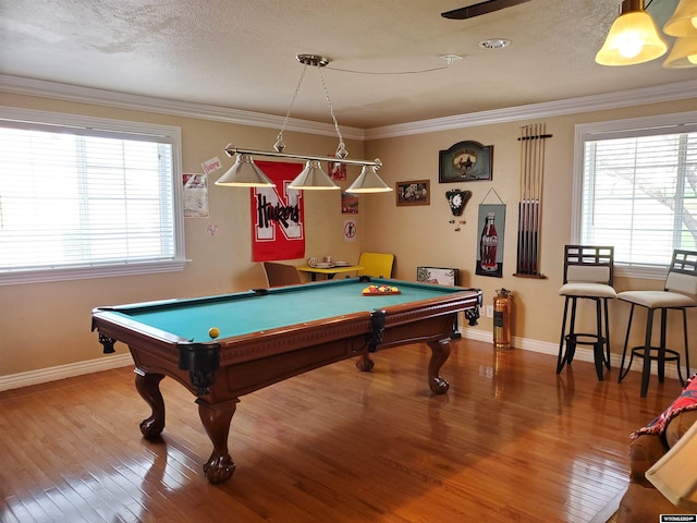 rec room featuring wood-type flooring, pool table, ornamental molding, and a wealth of natural light