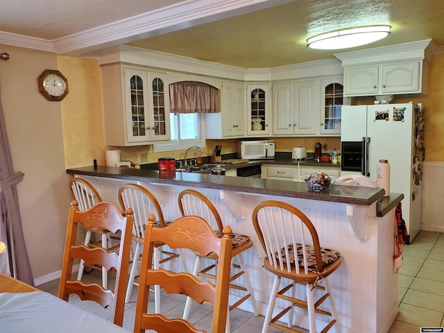 kitchen with kitchen peninsula, crown molding, a kitchen bar, and light tile patterned floors