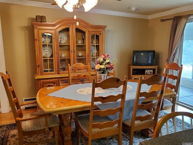 dining room with wood-type flooring, ornamental molding, and a baseboard radiator