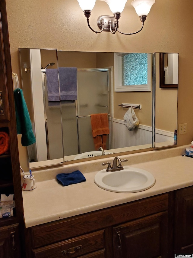 bathroom featuring an enclosed shower and vanity