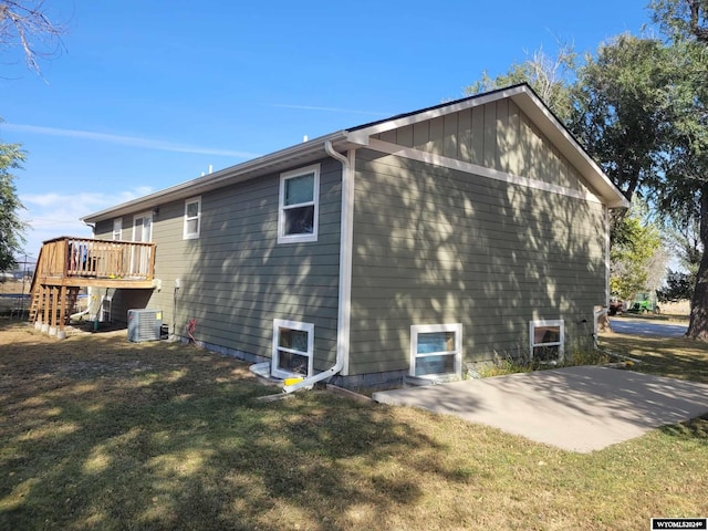 view of home's exterior featuring cooling unit, a deck, a lawn, and a patio