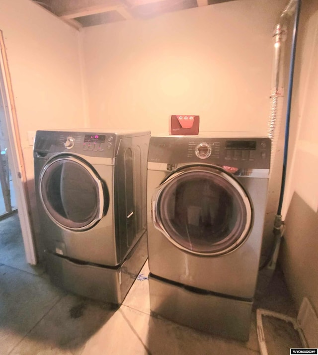 laundry room featuring washing machine and dryer and tile patterned floors