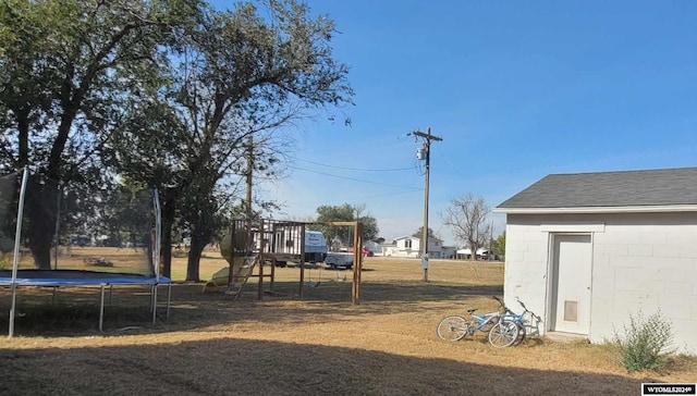 view of yard with a playground and a trampoline