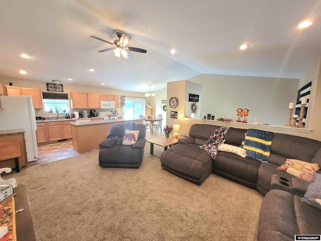 carpeted living room with ceiling fan with notable chandelier and lofted ceiling