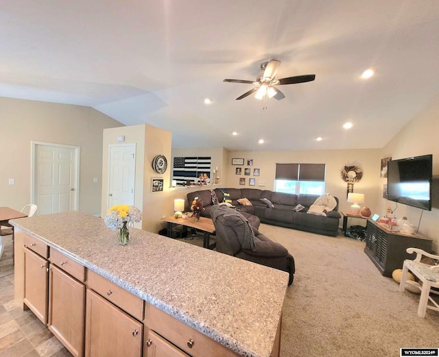 kitchen with light stone countertops, light brown cabinets, light carpet, vaulted ceiling, and ceiling fan