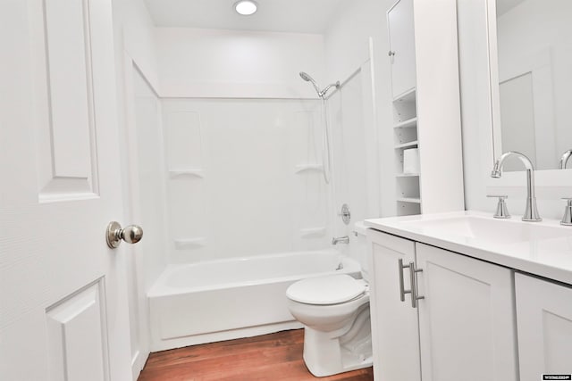 full bathroom with hardwood / wood-style floors, shower / washtub combination, vanity, and toilet