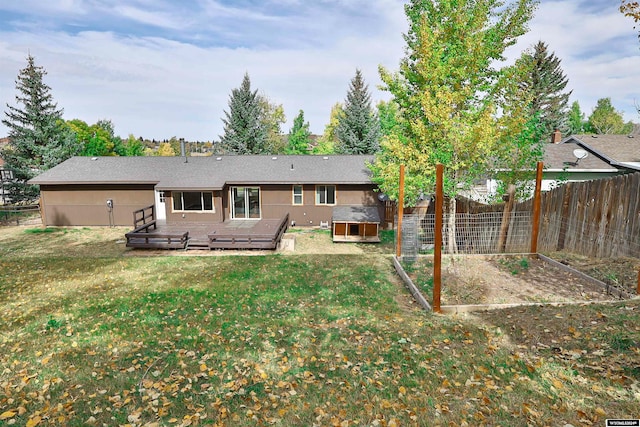 back of house featuring a wooden deck and a yard