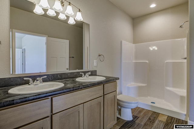 bathroom with vanity, wood-type flooring, toilet, and a shower