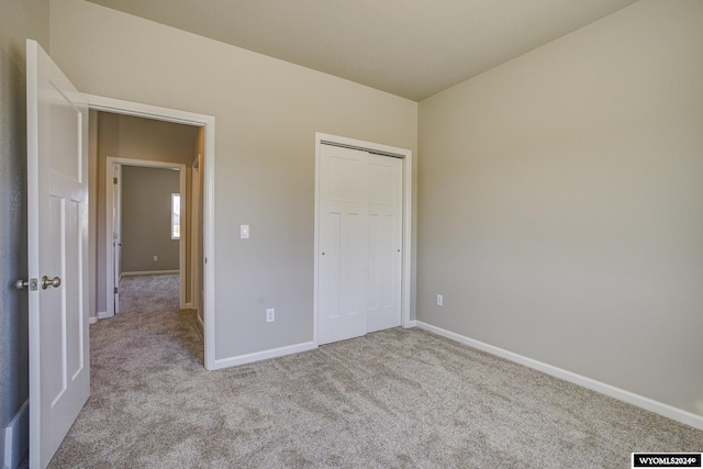 unfurnished bedroom featuring light carpet and a closet