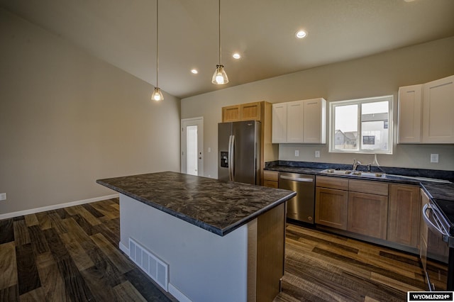 kitchen with sink, hanging light fixtures, a kitchen island, stainless steel appliances, and white cabinets