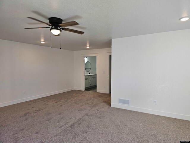 carpeted spare room with ceiling fan and a textured ceiling