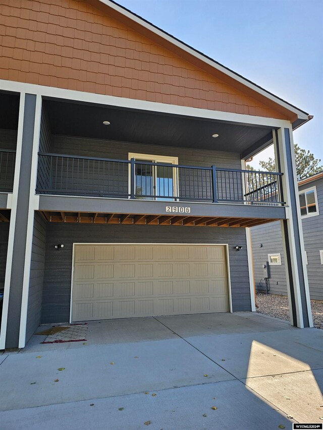 view of front of property featuring a garage and a balcony