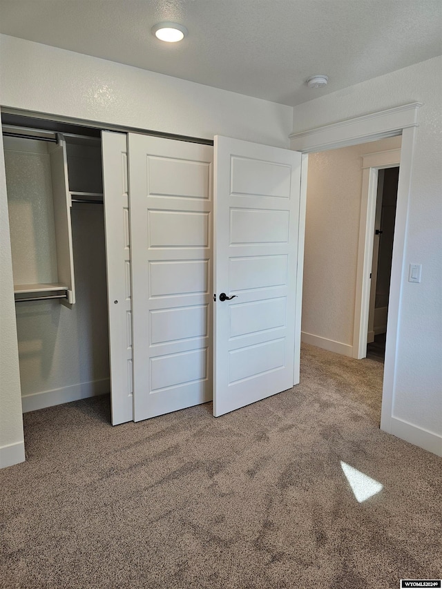 unfurnished bedroom with a closet and carpet flooring