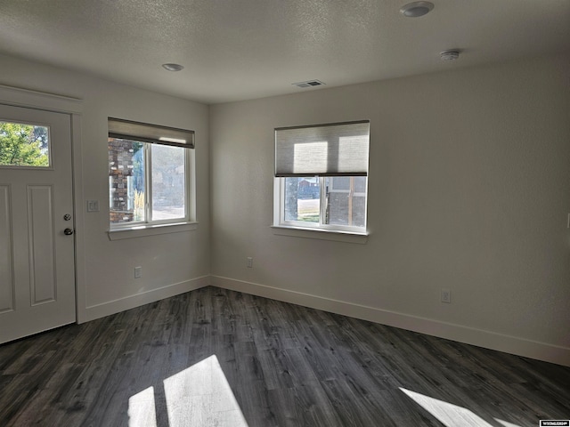 foyer entrance with a textured ceiling and dark hardwood / wood-style flooring