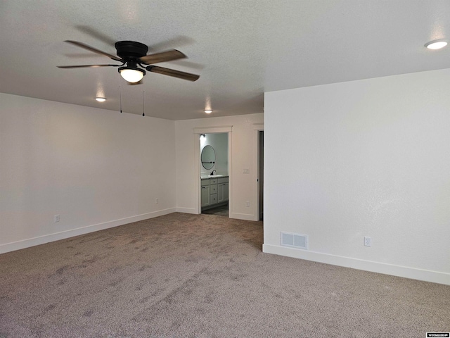 carpeted spare room with ceiling fan and a textured ceiling