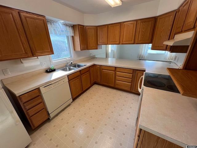 kitchen with white appliances, sink, and kitchen peninsula