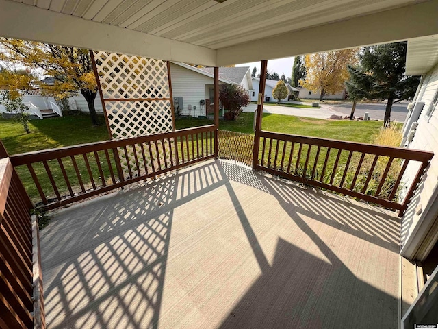 wooden deck featuring a lawn