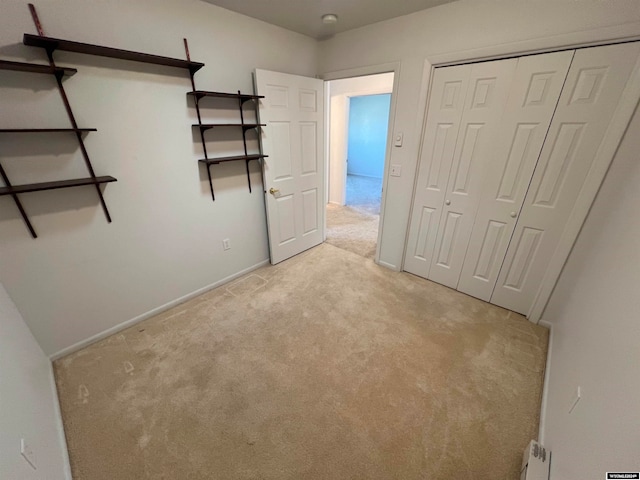 unfurnished bedroom with light carpet and a closet