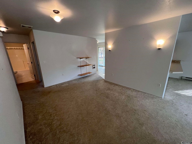 unfurnished living room with baseboard heating and carpet