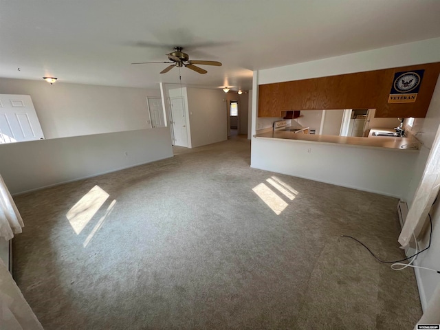 unfurnished living room with ceiling fan, a baseboard heating unit, and carpet