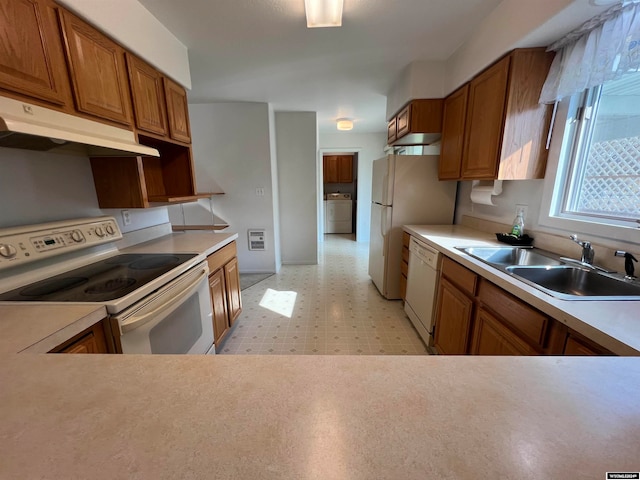 kitchen featuring washer / dryer, white appliances, sink, and heating unit